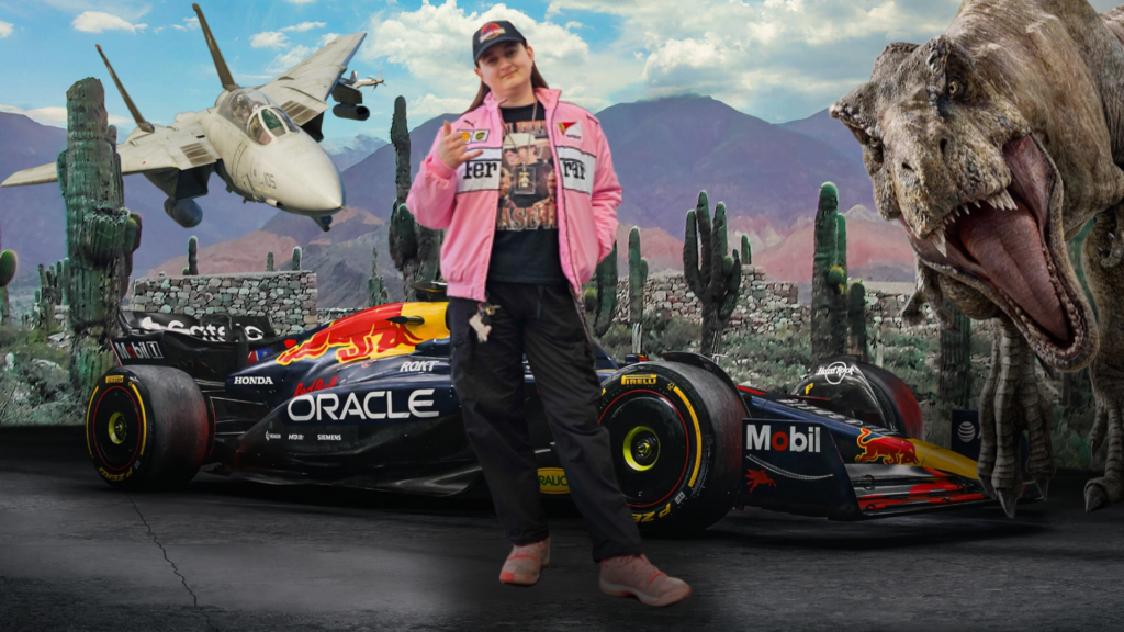 Eine Frau steht selbstbewusst vor einem futuristischen und surrealen Hintergrund in einer Wüstenlandschaft mit Kakteen und Bergen. Sie trägt eine schwarze Kappe, eine rosa Jacke mit Motorsport-Logos, ein dunkles T-Shirt, schwarze Hose und Turnschuhe. Hinter ihr steht ein Formel-1-Rennwagen im Design von Red Bull Racing. Links im Bild fliegt ein Kampfjet tief über die Szene, rechts erscheint ein großer Tyrannosaurus Rex mit geöffnetem Maul. Die Bildmontage wirkt wie ein fantasievolles Action-Poster und kombiniert Motorsport, Militärflugzeug und Dinosaurier in einer dramatischen Kulisse.