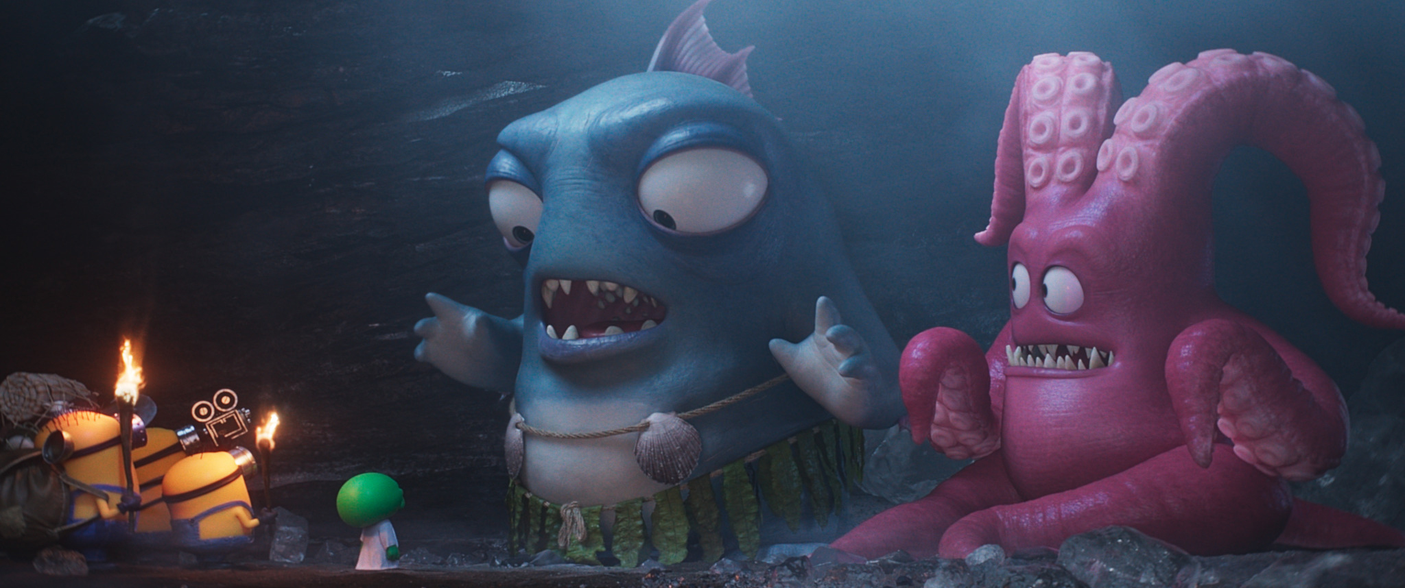 Drei Minions und eine kleine grüne Figur stehen im Fackelschein vor einem riesigen blauen Fischmonster und einem pinken Krakenmonster.
