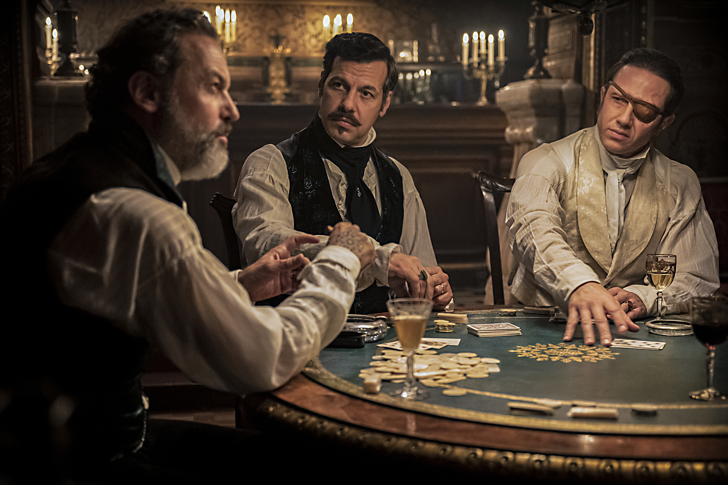 Szenenbild aus „Der Graf von Monte Christo“: Drei Männer in historischer Kleidung sitzen an einem runden Spieltisch und spielen Karten.